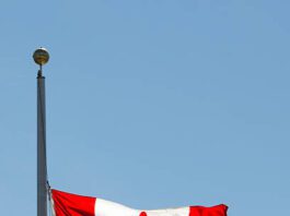 Canadian National Flag, Half-Mast against blue sky